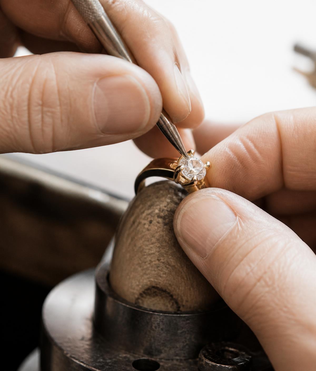 Jeweler setting diamonds by hand in the atelier